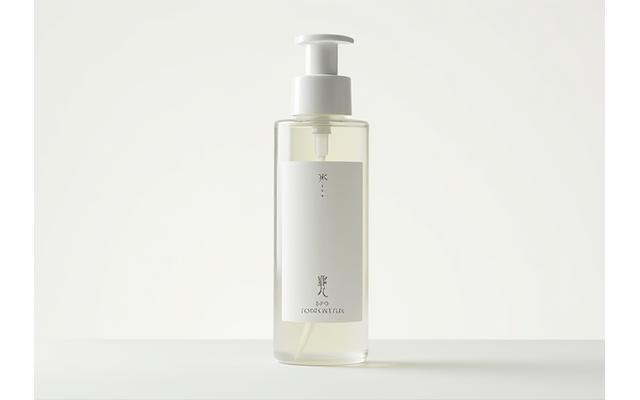 極限まで材料を削減した、ミニマルなデザインの化粧水ボトル。透明な容器に白いシンプルなラベルが貼られている。